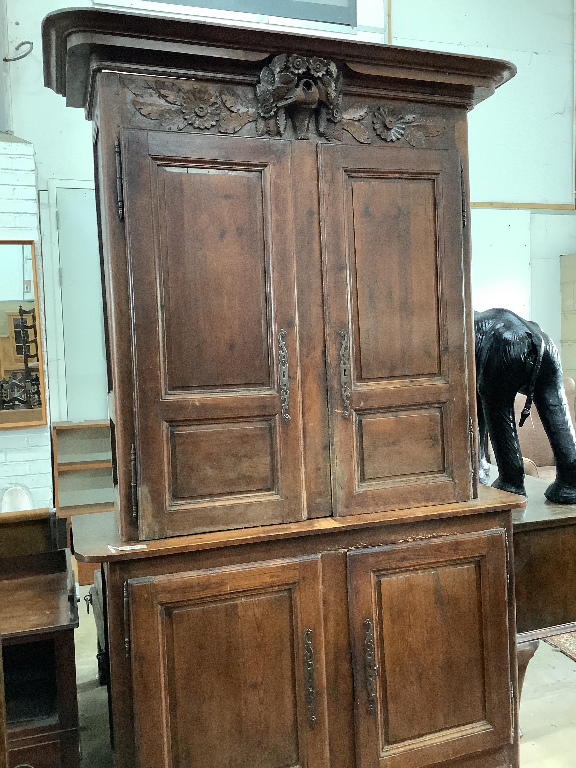 A 19th century Normandy pine marriage cupboard in two parts and carved with birds, width 141cm, depth 53cm, height 228cm